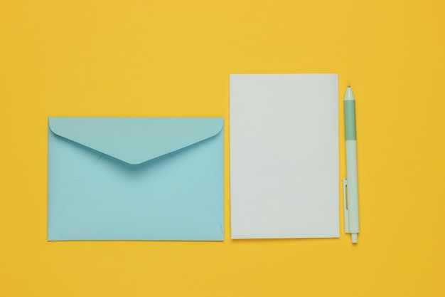 Enveloppe avec une lettre et un stylo sur fond jaune. Saint Valentin, mariage ou anniversaire. Vue de dessus