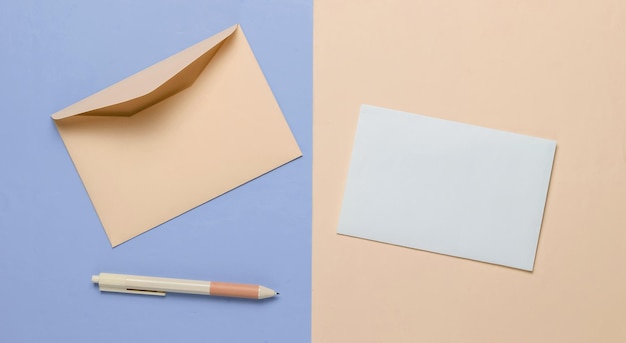 Enveloppe avec une lettre et un stylo sur un fond pastel rose bleu Saint Valentin mariage ou anniversaire Vue de dessus