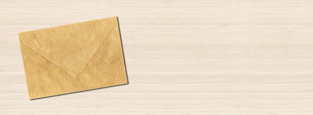 Enveloppe de papier brun sur fond de bois blanc