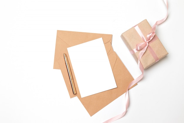 Enveloppe en papier kraft avec feuille blanche et boîte-cadeau surprise