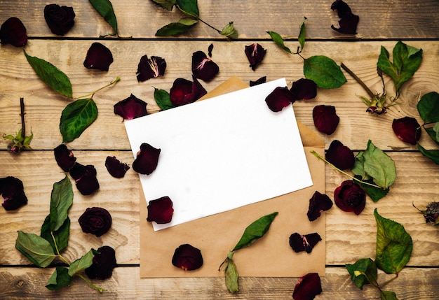 Une enveloppe postale parmi les pétales de rose séchés. Herbier et fleurs séchées.La mise en page d'une invitation ou d'une carte postale. Espace vide pour le texte.