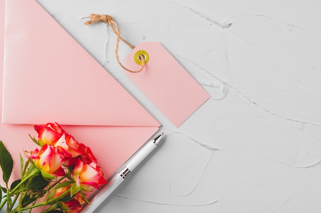 Enveloppe rose avec des fleurs, vue de dessus. Lettre romantique