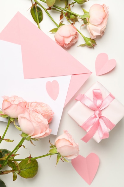 Enveloppe, roses, coeurs et boîte-cadeau sur fond blanc