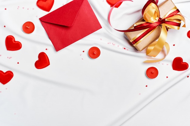 Enveloppe rouge boîte cadeau et cœurs sur feuille de soie blanche concept romantique fond de la Saint-Valentin