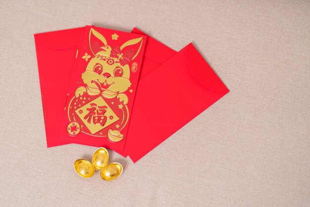 Enveloppe rouge chinoise avec un cadeau d'argent en lingots d'or pour les vacances du Nouvel An lunaire heureux La phrase chinoise signifie le bonheur en bonne santé Lucky and Wealthy