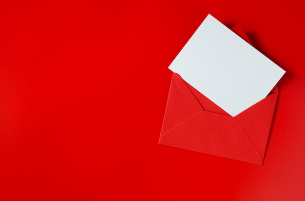 Enveloppe rouge avec du papier blanc vierge. Contexte de la Saint-Valentin. Maquette de lettre d'amour.