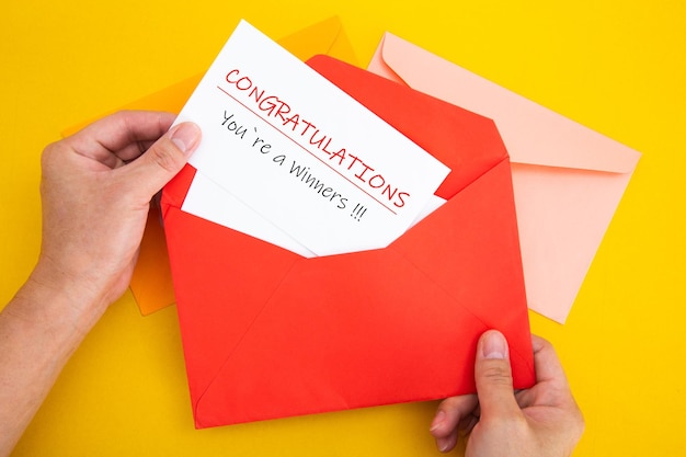 Enveloppe rouge ouverte à la main avec lettre Félicitations Vous êtes un gagnant