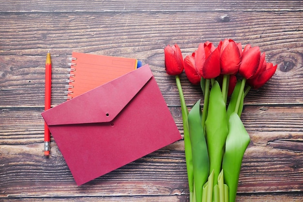 Enveloppe et tulipe rouge sur table