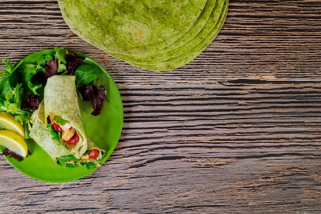 Envelopper de poulet grillé et de légumes sur des tortillas aux épinards