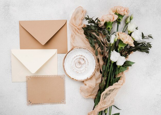 Photo enveloppes d'invitation de mariage vue de dessus avec des fleurs