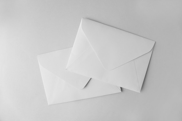 Enveloppes en papier blanc sur la vue de dessus de fond gris clair