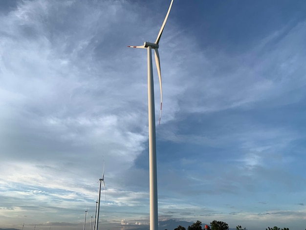 Une éolienne est devant un ciel nuageux.