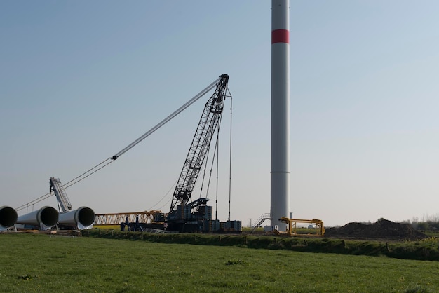 Photo des éoliennes sur un champ herbeux contre le ciel