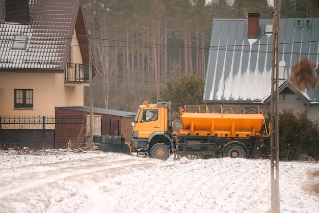 Épandeur de sel ou camion de sel nettoyant la route dans la campagne après de fortes chutes de neige