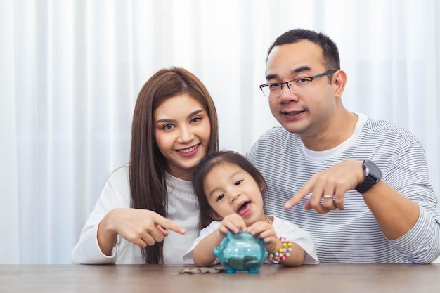 L'épargne familiale, la planification budgétaire, l'argent de poche des enfants.La mère de famille asiatique plus loin et sa fille montrent une tirelire tirelire