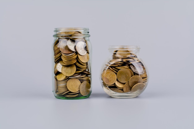 Épargner de l'argent pièces dans une bouteille de verre Concepts d'épargne d'argent flux de trésorerie actifs et immobilier