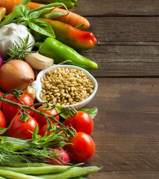 Épeautre Dans Un Bol Et Légumes Frais Sur Une Table En Bois