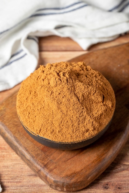 épice de cannelle en poudre cannelle moulée dans un bol sur un fond en bois concept d'épice sèche en gros plan