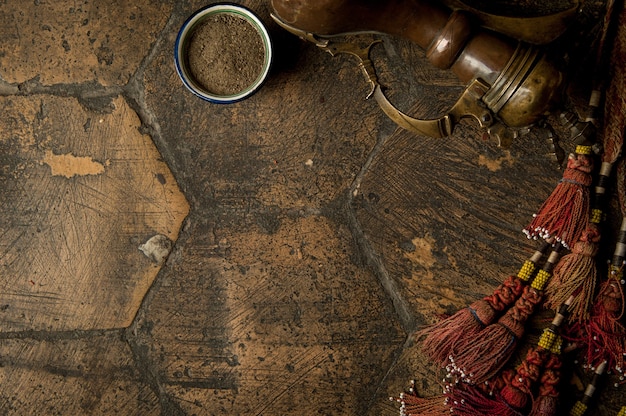 Photo Épices de l'est avec une cruche en cuivre et un fouet décoratif sur un vieux pavé usé