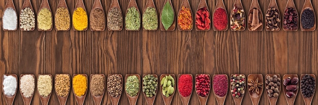 Épices Et Herbes Colorées Comme élément De Conception D'emballages Alimentaires. Collection De Condiments Dans Des Cuillères En Bois Sur Fond De Table.