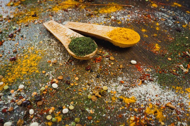 Épices et herbes dans des cuillères en bois