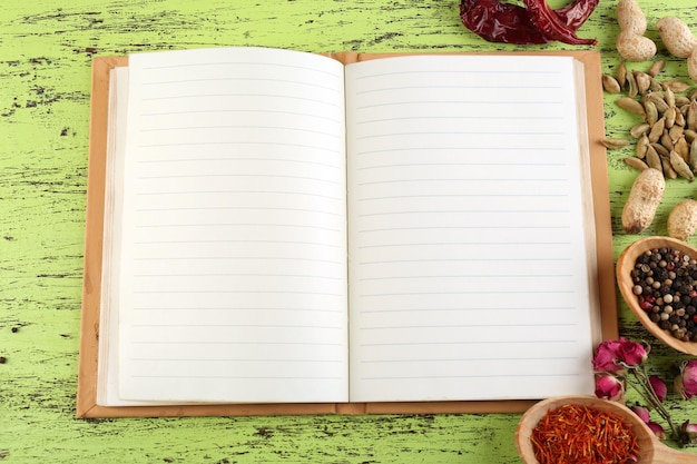 Photo Épices avec livre de recettes sur fond de table en bois de couleur