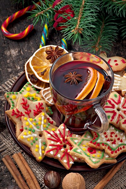 Des épices de vin chaud et un biscuit au pain d'épice sur un fond en bois dans un style rustique