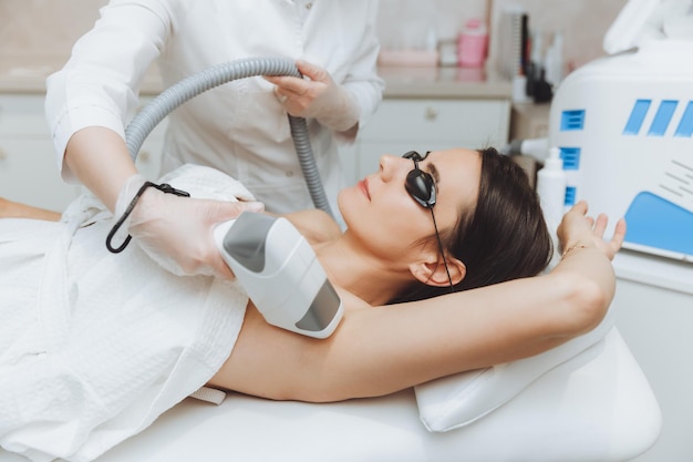 Épilation Au Laser Des Aisselles Cosmétologue Enlevant Les Poils Des Aisselles D'une Jeune Femme épilation Au Laser Dans Une Clinique De Beauté Cosmétique Le Concept De Santé Et De Beauté