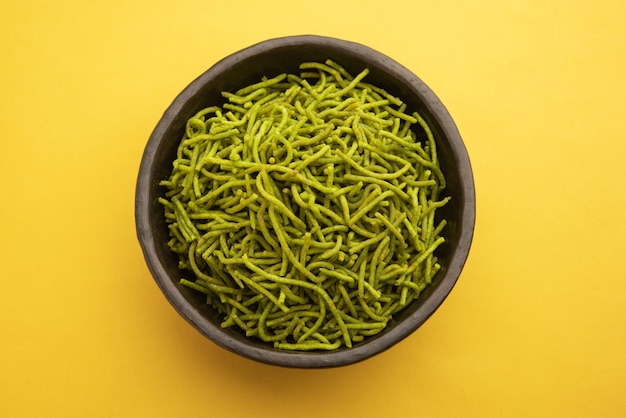 Les épinards ou palak sev sont des nouilles salées frites croustillantes. Le shev ou le namkeen vert épais et mince fait maison est une collation indienne classique