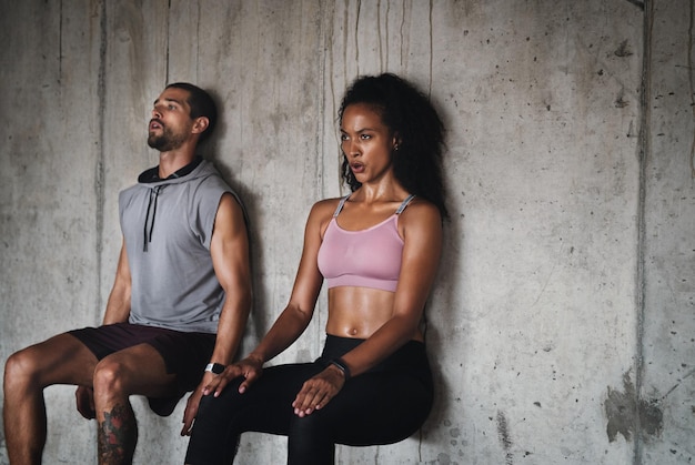 L'équilibre est la plus grande forme de force Photo d'un jeune couple sportif faisant de l'exercice contre un mur à l'intérieur d'un parking souterrain