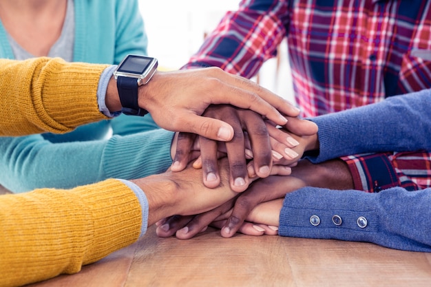 Équipe des activités empiler les mains sur le bureau au bureau créatif