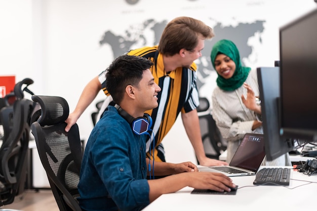 Photo Équipe d'affaires de démarrage multiethnique femme arabe portant un hijab lors d'une réunion dans un brainstorming intérieur de bureau ouvert moderne, travaillant sur un ordinateur portable et un ordinateur de bureau. mise au point sélective. photo de haute qualité