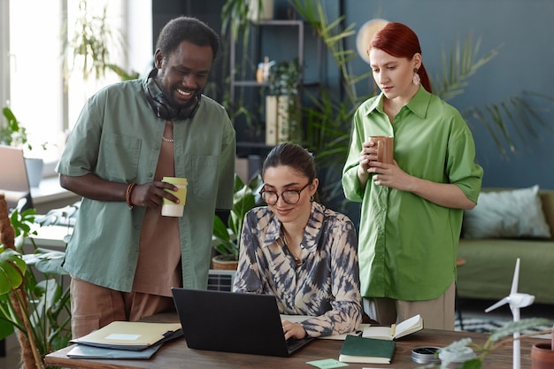 Photo une équipe d'affaires diversifiée utilisant un ordinateur portable dans un bureau vert