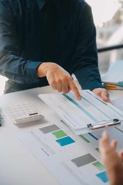 Équipe d'affaires travaillant avec un nouveau plan de projet de démarrage et discutant d'informations pour la stratégie financière avec un ordinateur portable et une tablette numérique dans un salon d'affaires moderne