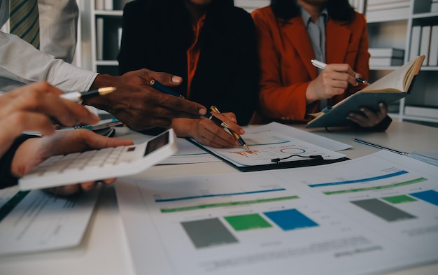 Équipe d'affaires travaillant avec un nouveau plan de projet de démarrage et discutant d'informations pour la stratégie financière avec un ordinateur portable et une tablette numérique dans un salon d'affaires moderne