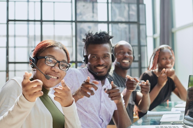 Une équipe afro-américaine travaillant au bureau du centre d'appels pour aider les gens avec l'assistance de télémarketing