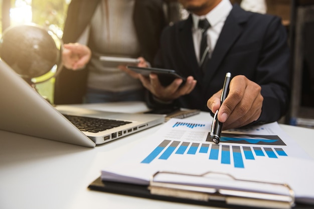 Équipe d'analystes commerciaux discutant de la stratégie commerciale dans une salle de bureau contemporaine avec un arrière-plan flou