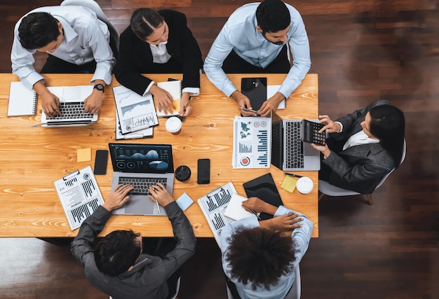 L'équipe d'analystes multiraciaux, vue de dessus panoramique, utilise l'affichage du tableau de bord BI sur l'écran d'un ordinateur portable, analysant les données financières pour une décision stratégique. Fintech analyse les indicateurs marketing Concord