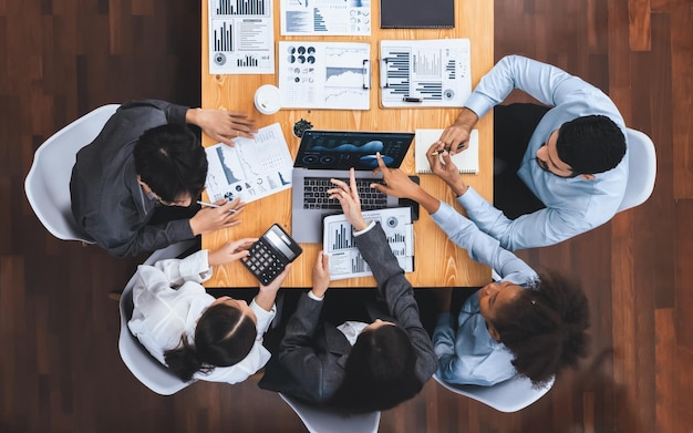 L'équipe d'analystes multiraciaux vue de dessus utilise l'affichage du tableau de bord BI sur l'écran d'un ordinateur portable analysant les données financières pour une décision stratégique. Fintech analyse les indicateurs marketing Concord