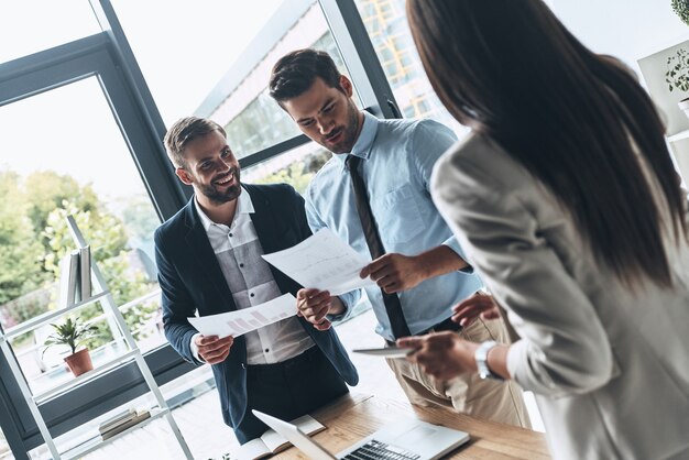 Photo Équipe au travail. groupe de jeunes gens modernes dans des vêtements décontractés intelligents discutant des affaires