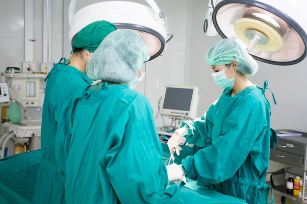 Photo l'équipe de chirurgie travaillant ensemble dans la salle d'opération de l'hôpital