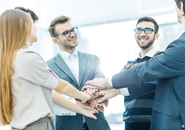 équipe commerciale amicale debout en cercle et joignant ses mains