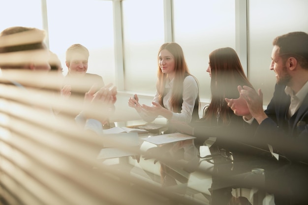 L'équipe commerciale applaudit assis à la table de bureau