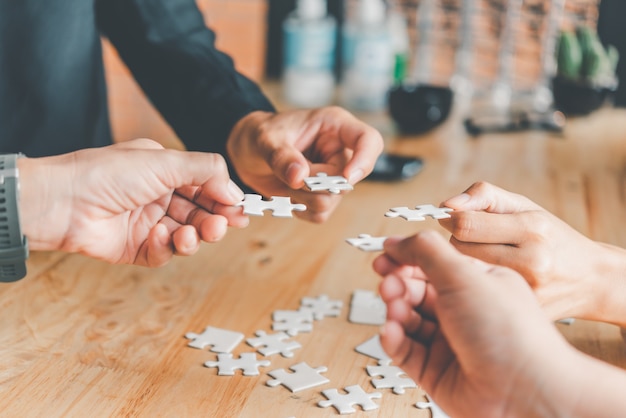 L'équipe commerciale gère un morceau de puzzle blanc qui est sur le point de tomber pour obtenir une feuille de travail complète - Une tentative de réussite.