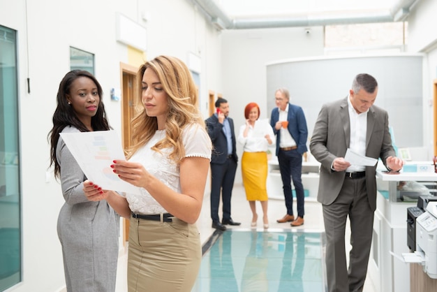 Équipe commerciale d'hommes et de femmes dans un bureau analysant l'évolution de l'entreprise