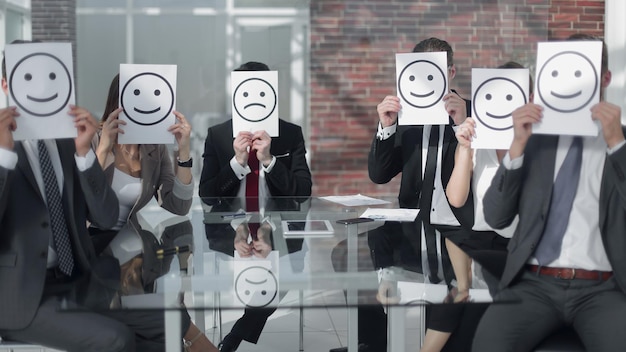 Photo Équipe commerciale avec des icônes souriantes assis au bureau