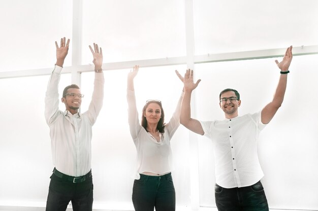 Photo une équipe commerciale prospère se tient les mains en l'air. photo avec espace copie