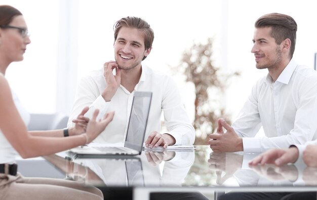 Photo Équipe commerciale souriante assise au bureau