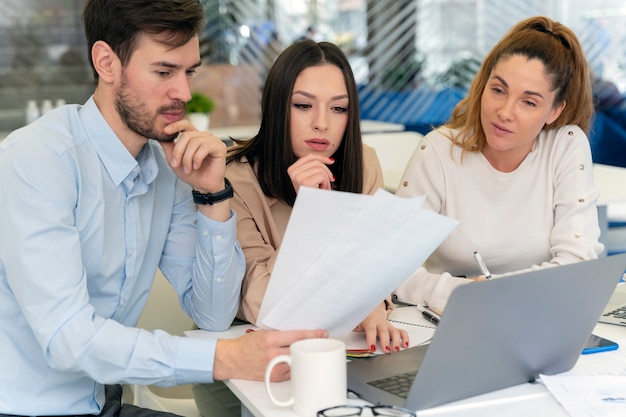 Équipe commerciale travaillant ensemble au bureau avec ordinateur portable