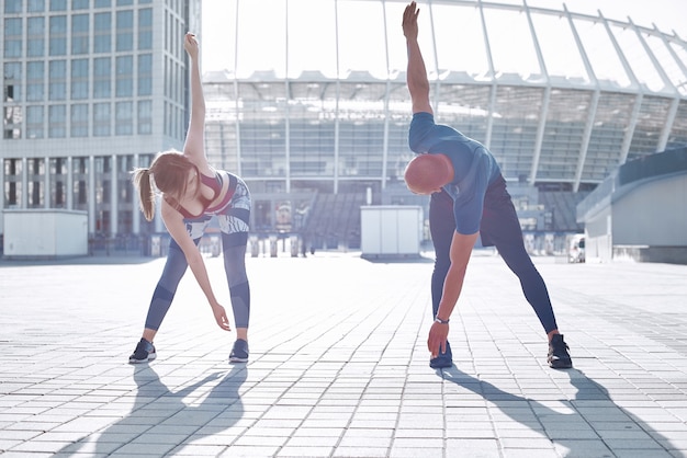 L'équipe de coureurs en bonne santé des sports urbains s'échauffe et s'étire dans le parc de la ville avant l'entraînement du matin